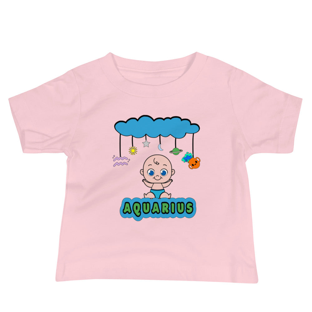 pink baby t-shirt featuring joyful light-skinned baby and a mobile with a cloud, star, moon, Aquarius symbol, Saturn, and a cartoon pot spilling water. The design combines playful celestial elements with a cozy fit