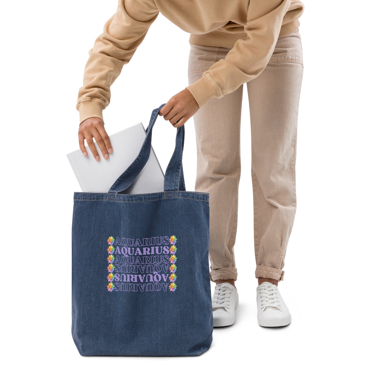 Denim tote bag featuring colorful flowers with the word ‘Aquarius’ repeated in a vertical row in purple text. The design combines floral elegance with a touch of celestial charm