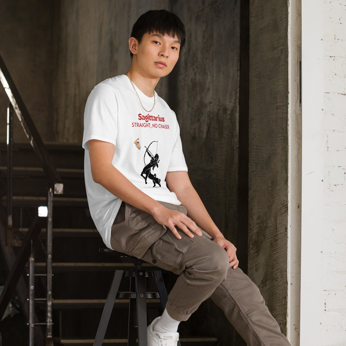 model wearing A white t-shirt lying flat on a light background, featuring a bold "Sagittarius - Straight, No Chaser" design. The graphic showcases a black centaur archer aiming at a drink, embodying the fearless and straightforward nature of Sagittarius.