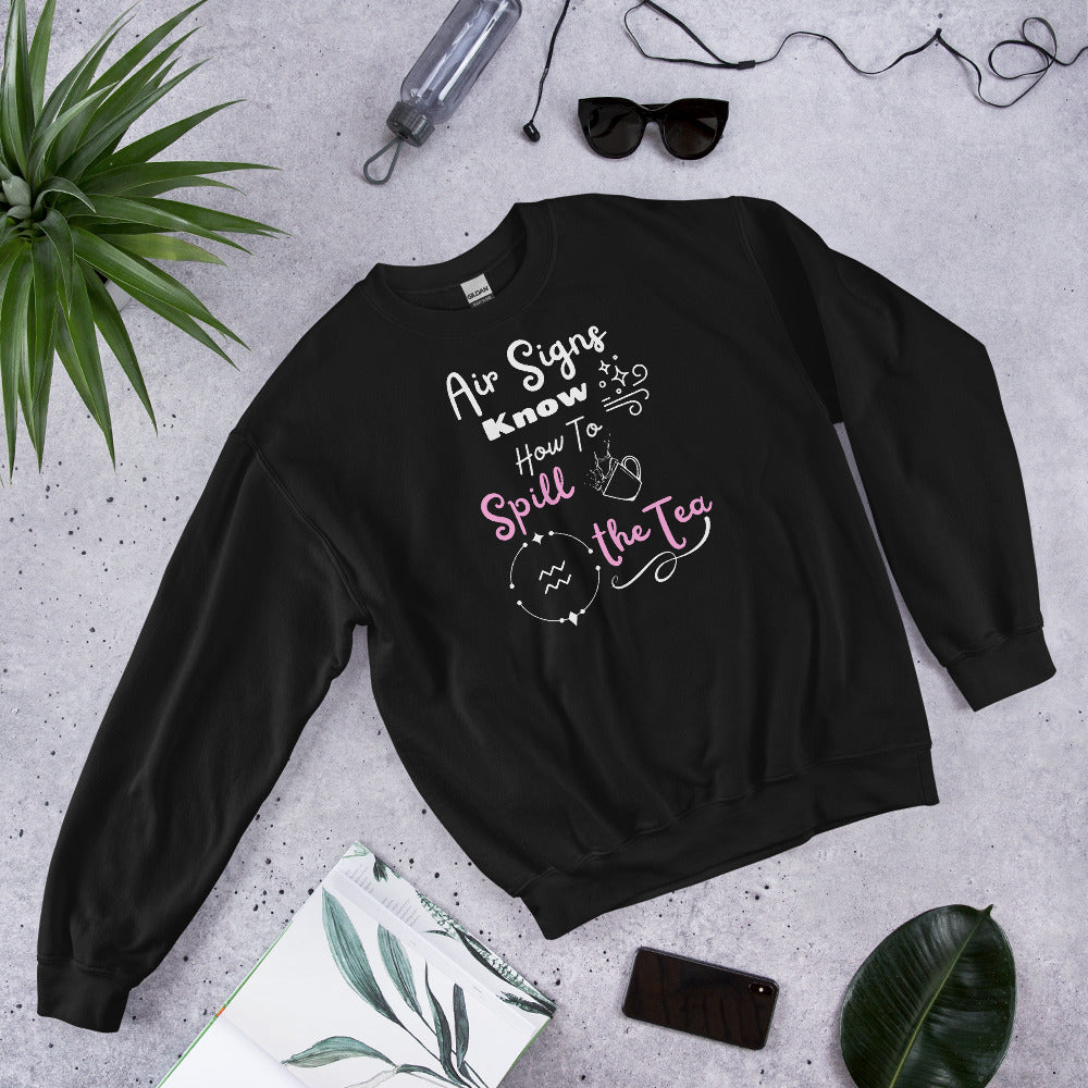 Black sweatshirt with white and pink text that says air signs know how to spill the tea. Aquarius astrology symbol with splashing teacup