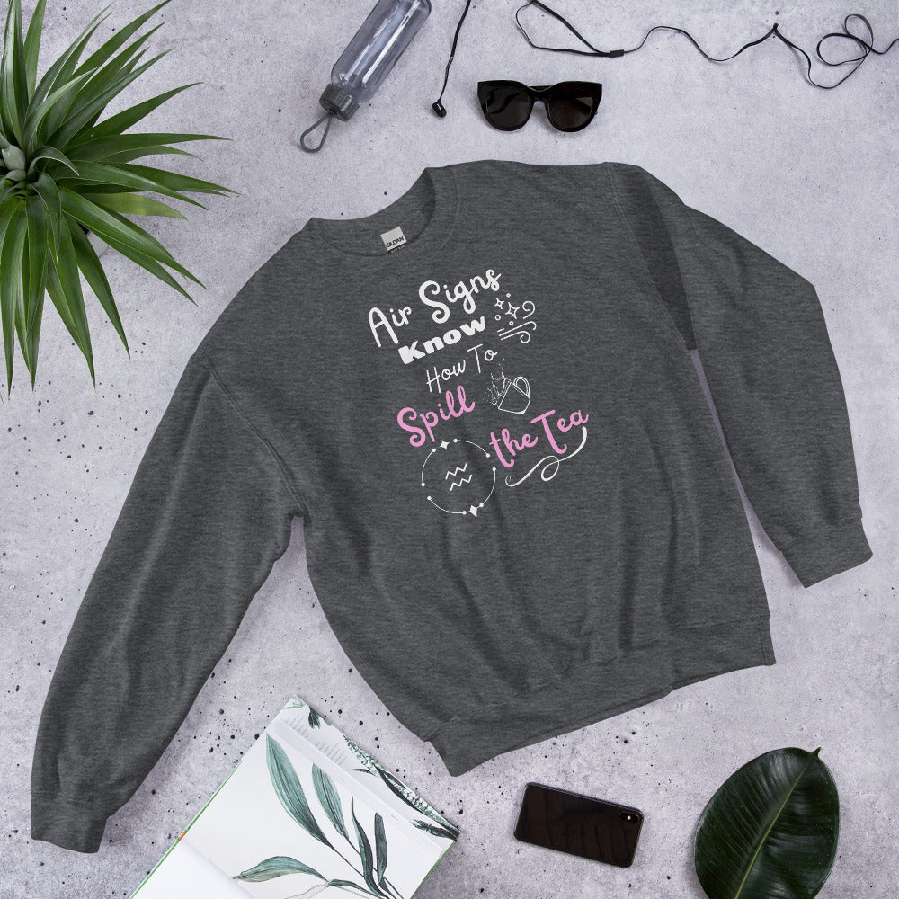 Grey Gildan sweatshirt with black and white text that says air signs know how to spill the tea. Aquarius astrology symbol with splashing teacup