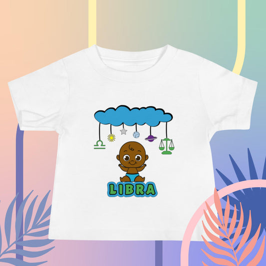 White zodiac infant t-shirt with libra symbols featuring a joyful black baby underneath a creative cloud mobile design