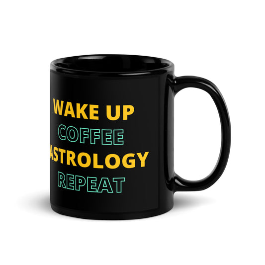 Black ceramic coffee mug featuring yellow and teal text that reads 'Wake Up, Coffee, Astrology, Repeat