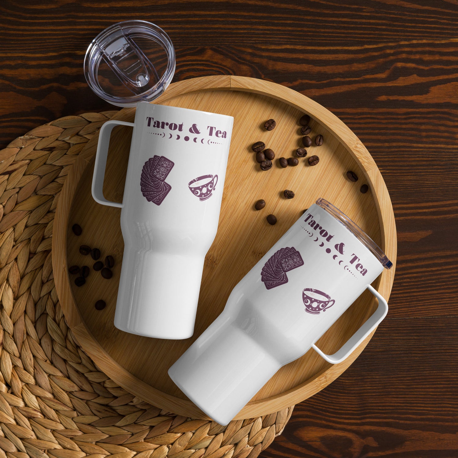 Two white Tarot & Tea Travel Mugs with maroon, burgundy text, moon phase graphic, tarot cards graphic, and teacup graphic.