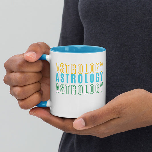 White ceramic coffee mug featuring bold yellow, blue , and green 'Astrology' text